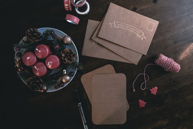 DIY Cozy - four maroon votive candles on teal ceramic plate surrounded by ornaments