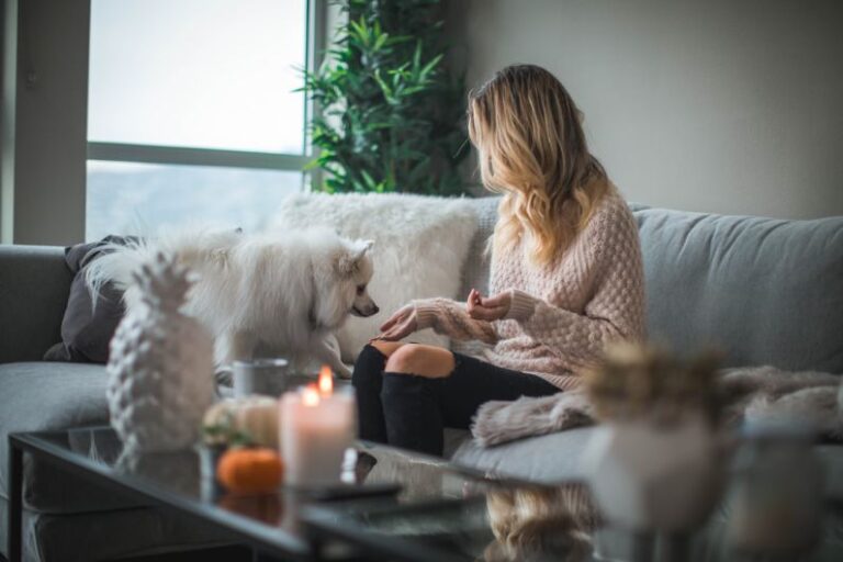 Pet-friendly Plants - woman sitting on sofa while holding food for dog