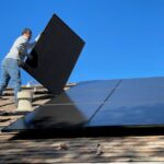 Solar Panels - man in white dress shirt and blue denim jeans sitting on white and black solar panel