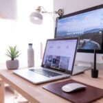 Office Gadgets - MacBook Pro on table beside white iMac and Magic Mouse