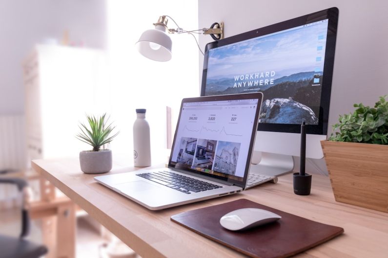 Office Gadgets - MacBook Pro on table beside white iMac and Magic Mouse