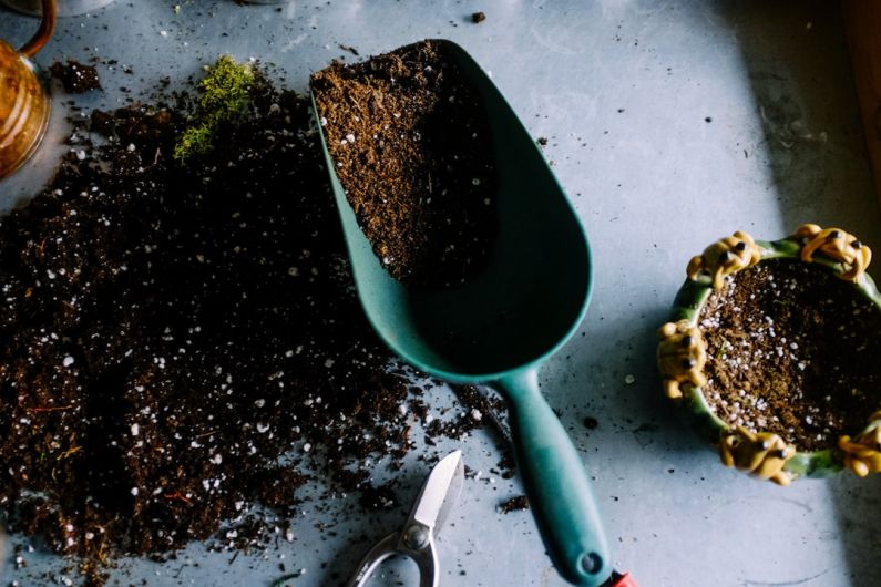 Gardening Gadgets - green metal garden shovel filled with brown soil