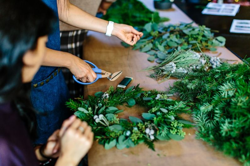 Wreaths - person holding scissors and leaf wreath