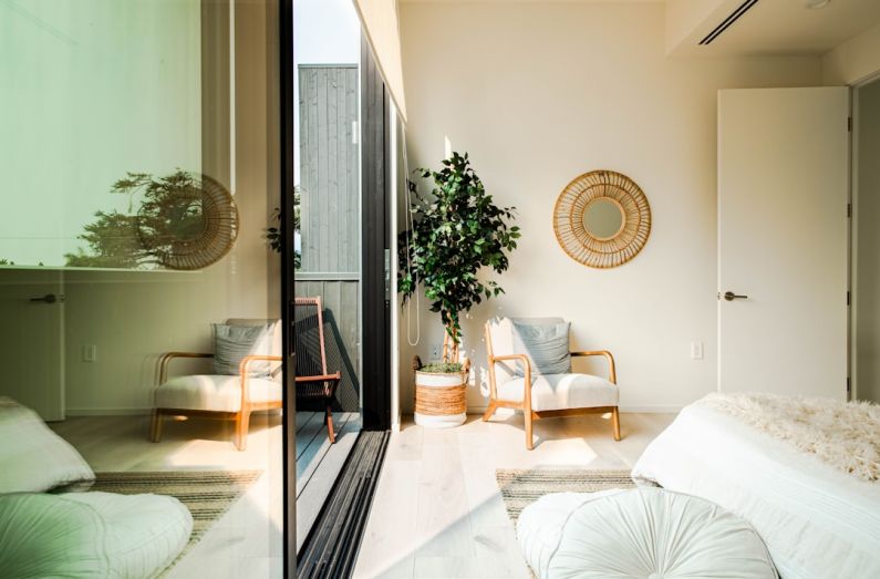 Natural Light - white and brown wooden armchair beside white and brown round wall mirror