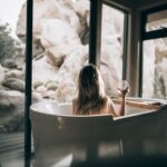 Home Spa - woman in white bathtub holding clear drinking glass