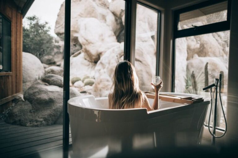 Home Spa - woman in white bathtub holding clear drinking glass