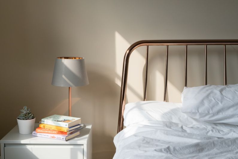 Restful Bedroom - table lamp on white wooden nightstand beside bed