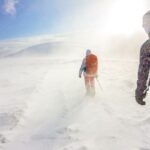 Outdoor Storage - two men walking on snow under blue sky