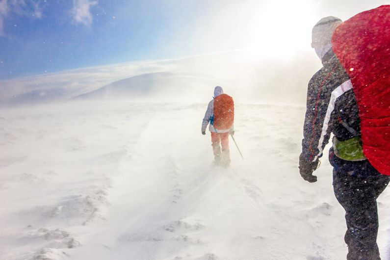 Outdoor Storage - two men walking on snow under blue sky