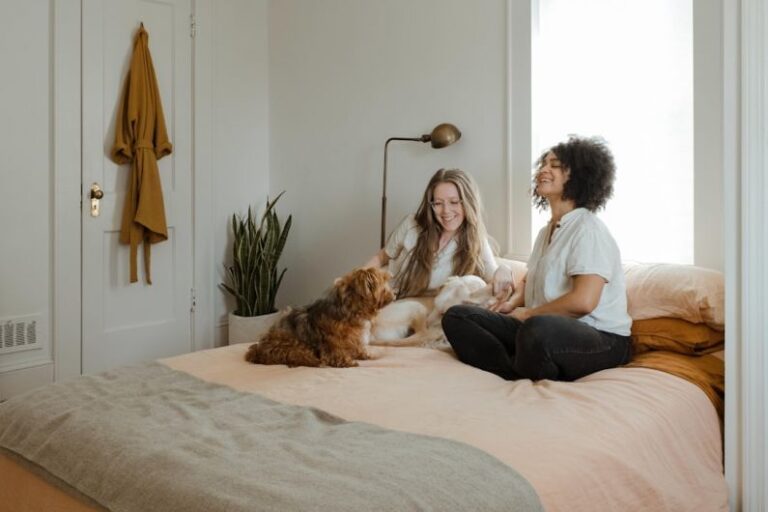 Pet-friendly Flooring - woman in white long sleeve shirt sitting on bed beside brown dog